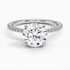 a round cut diamond ring with pave set shoulders