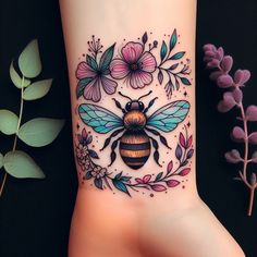 a tattoo on the wrist of a woman with flowers and a bee in the center