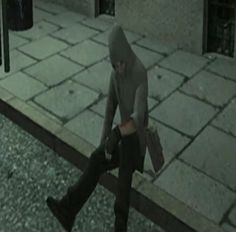 a person walking down the street in a hooded outfit