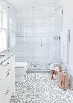 a bathroom with white and gray tiles on the floor