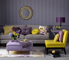 a living room filled with purple and yellow furniture in front of a wall mounted mirror