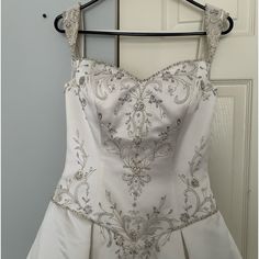 a wedding dress hanging on a hanger in front of a door with a white background