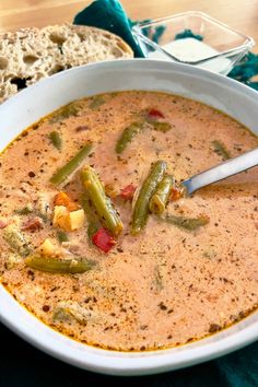 a white bowl filled with soup next to bread