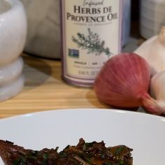 a piece of food on a plate next to garlic and other ingredients in the background