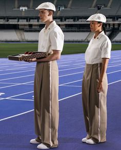 two people standing on a tennis court holding trays