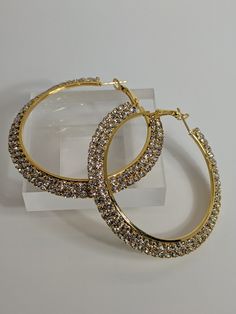 Make a BOLD statement while adding a touch of style and class to your look in these gorgeous hoop earrings, embellished in the finest premium grade crystals that add just the right amount of sparkle. Gold Hoop Crystal Earrings For Party, Glamorous Crystal Rhinestone Hoop Earrings, Glamorous Rhinestone Crystal Hoop Earrings, Gold Bling Hoop Earrings, Elegant Gold Hoop Earrings With Bling, Glamorous Metal Hoop Earrings With Bling, Gold Metal Hoop Earrings With Bling, Gold Metal Hoop Earrings With Rhinestones, Metal Hoop Crystal Earrings With Rhinestones