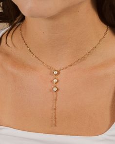 Introducing the Reine Lariat Necklace, a luxurious piece crafted for the sophisticated individual. This elegant necklace features a delicate beaded chain adorned with lustrous pearls, exuding an air of exclusivity and refinement. Elevate any outfit with the timeless style and grace of the Reine Lariat Necklace. Material: 14K gold or rhodium plated brass, freshwater pearls Features: Measures 16" with 2" extender, 3.75" drop, 0.35" pendants, 5mm pearls, 2mm chain, Lead & Nickel free, lobster clasp Elegant Pearl Charm Dangle Lariat Necklace, Elegant Pearl Charm Lariat Necklace With Dangle, Elegant Lariat Necklace With Pearl Charm Dangle, Elegant Adjustable Beaded Chain Necklace, Elegant Lariat Backdrop Necklace With Delicate Chain, Elegant Pearl Pendant Backdrop Necklace For Party, Elegant Gold Dangle Backdrop Necklace, Elegant Long Lariat Necklace For Formal Occasions, Luxury Pearl Lariat Necklace