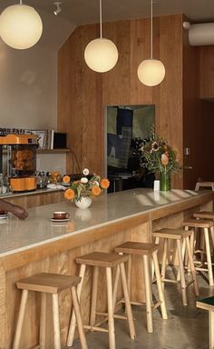 a kitchen filled with lots of counter top space and wooden stools next to it