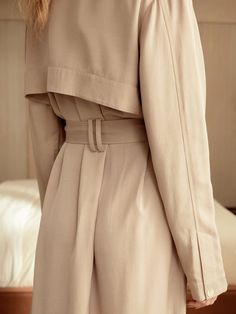 If there ever was a perfect lightweight trench, this is it. Made of a luxurious and flowy fabric, it's a stunning layering piece and can also be worn buttoned up as a dress. The color lies beautifully between beige and tan, providing a soft neutral tone that goes with literally anything in your closet, including all of our capsule pieces. With a tie belt, beautiful horn style buttons, lovely pleats, side slits and a back flap, its intentional design is what sets us apart. Whatever you pair this Elegant Beige Belted Outerwear, Elegant Beige Outerwear For Daywear, Elegant Long Outerwear For Daywear, Elegant Neutral Outerwear For Daywear, Beige Formal Outerwear With Belted Cuffs, Formal Beige Outerwear With Belted Cuffs, Beige Outerwear With Belted Cuffs For Spring, Elegant Cream Outerwear With Belted Cuffs, Beige Belted Cuffs Outerwear For Spring