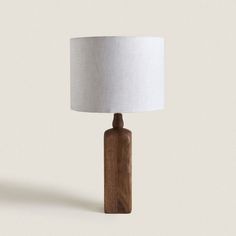 a wooden table lamp with a white shade