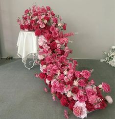 a bunch of flowers that are sitting on the floor next to a vase with pink and white flowers in it