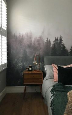 a bed room with a neatly made bed and a painting on the wall