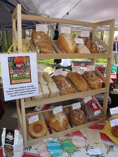 an assortment of breads on display under a tent