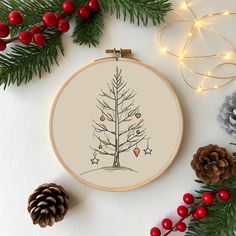 a cross stitch christmas tree with ornaments around it