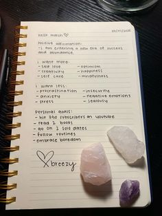 a notepad with some rocks on top of it next to a pen and glasses