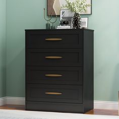 a black chest of drawers in a room with a mirror on the wall above it