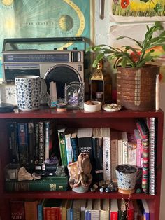 a bookshelf filled with lots of books next to a painting on the wall