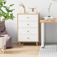 a white and wooden dresser next to a plant