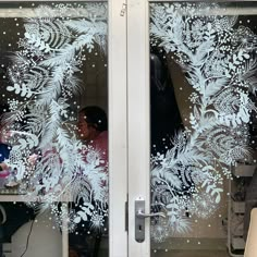 two people sitting at a table behind frosted glass doors