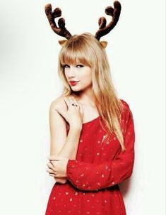 a woman with long blonde hair wearing reindeer antlers on her head and red dress