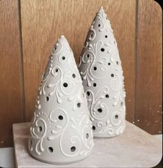 two white vases sitting on top of a table