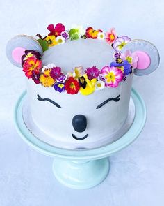 a cake decorated with flowers and a mouse face