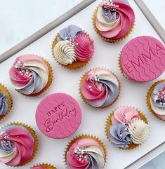 cupcakes decorated with pink, blue and white frosting are on a tray