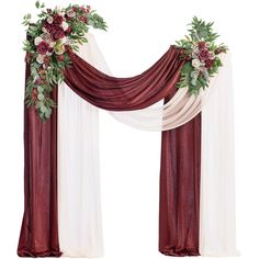 a red and white wedding arch decorated with flowers, greenery and satin drapes