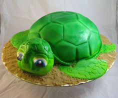 a cake shaped like a turtle sitting on top of sand