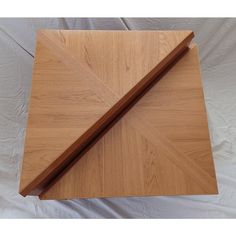 a wooden cutting board sitting on top of a white sheet