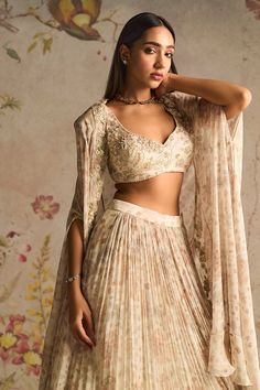 Elevate your style with this stunning ivory ensemble. The printed chiffon embroidered blouse pairs beautifully with the printed chiffon skirt, and the look is completed with an embroidered cape. This outfit is perfect for adding a touch of elegance to any special occasion. Ivory Lehenga Bridesmaid, Ivory Lehenga, Cape Lehenga, Ridhi Mehra, Cape Set, Chiffon Cape, Skirt Chiffon, Embroidered Cape, Printed Lehenga