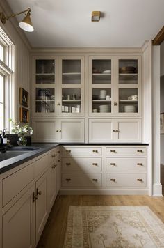 a large kitchen with white cabinets and black counter tops, along with an area rug on the floor