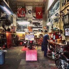 a garage filled with lots of motorcycles and other things to see on the wall in front of it