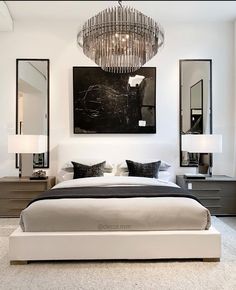 a bedroom with a chandelier hanging above the bed