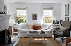 a living room filled with furniture and a fire place in front of a white fireplace