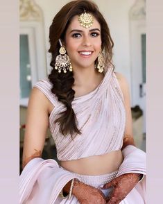 a woman in a white sari and gold jewelry