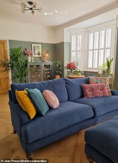 a living room with blue couches and pillows