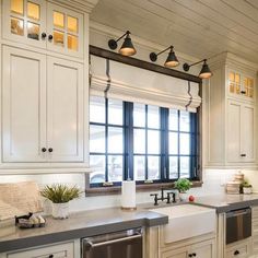 a kitchen with white cabinets and stainless steel appliances, along with an island in the middle