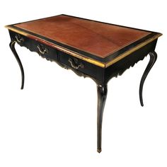 an antique black and brown table with two drawers on one side, the top is turned upside down