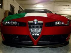 a red sports car with a green and white flag on it's front end