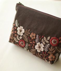 a brown purse with flowers and leaves on it