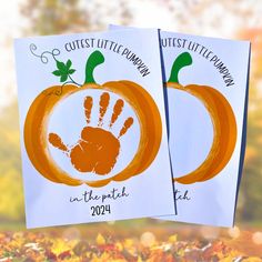 two pumpkins with handprints on them are shown in front of fall leaves