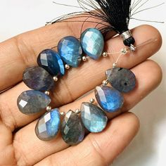 a person holding some kind of blue and grey beaded necklace in their left hand