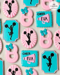 decorated cookies are arranged in the shape of numbers and cheerleaders on blue and pink icing