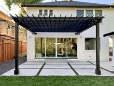 an outdoor patio with a pergolan and sliding glass doors