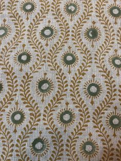 an upholstered fabric with green and gold designs on it's side,