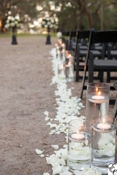 the aisle is lined with candles and petals