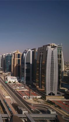 an aerial view of a city with tall buildings and train tracks in the foreground