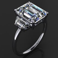 an emerald cut diamond ring on a black background