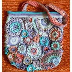 a crocheted purse is sitting on an orange surface